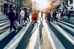 Crowd of pedestrians crossing a city street, illustrating sonder meaning and the hidden complexity of strangers' lives.