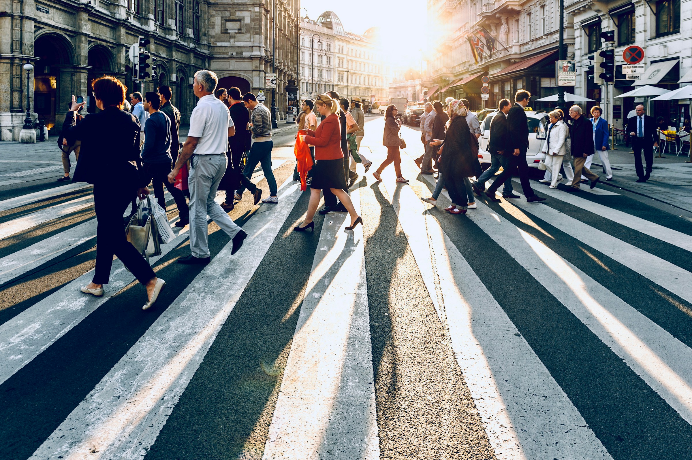Crowd of pedestrians crossing a city street, illustrating sonder meaning and the hidden complexity of strangers' lives.